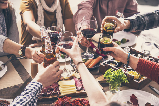 Grupo de pessoas que têm refeição juntos jantar brindar copos
 - Foto, Imagem