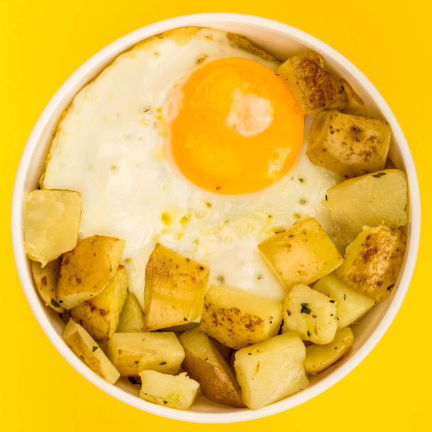 Жареное яйцо с жареной картошкой в миске
 - Фото, изображение