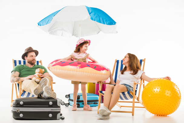 Flotációs gyűrű szülők ül elszigetelt fehér, utazási koncepció napozóágyak között állandó, boldog kis gyerek - Fotó, kép