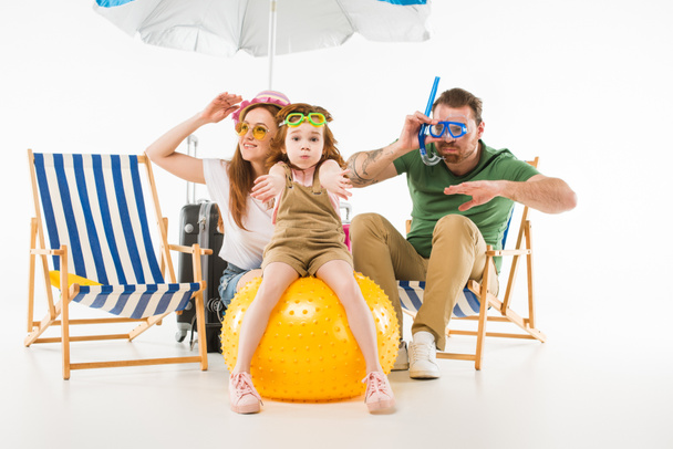 Family in swimming goggles depicting swim with sunshade, sun loungers and ball isolated on white, travel concept - Photo, Image