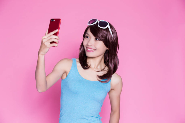 woman taking selfie happily on the pink background - 写真・画像