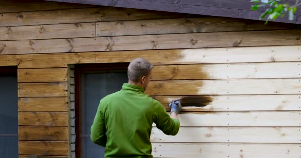 pintor con pinceles pintura casa fachada con madera color protector
 - Metraje, vídeo