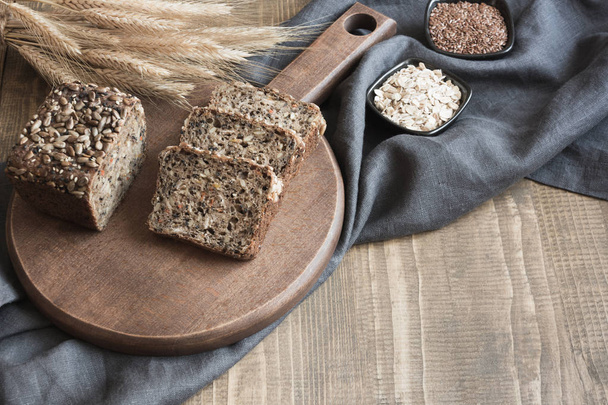 A loaf of fresh rustic rye bread on wooden board. Healphy food background. Close up. Copy space. Fitness wholegrain bread. - Foto, immagini