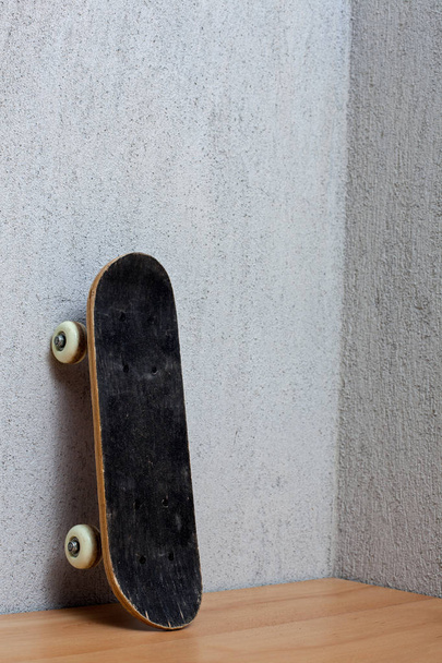 Skateboard standing on a wall. - Foto, Imagen