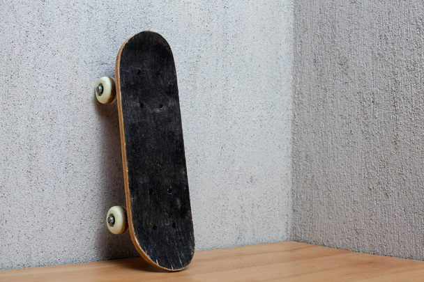 Skateboard standing on a wall. - Fotografie, Obrázek