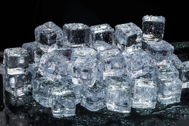 Ice cubes on black wet table. Selective focus. - Zdjęcie, obraz