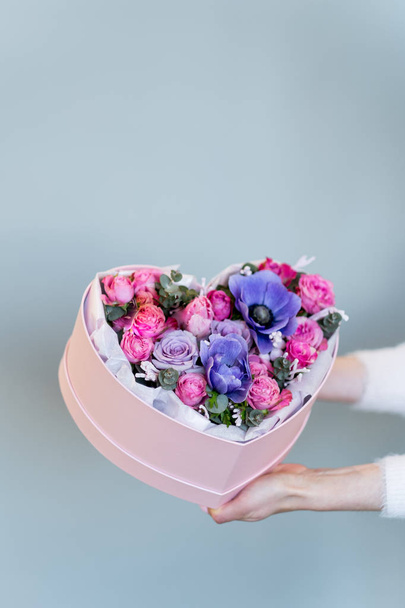female hands holding heart shaped gift box with flowers - Foto, Bild