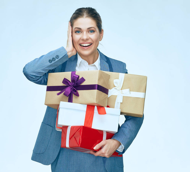 portrait of happy businesswoman in suit holding pile of gift boxes  - Fotó, kép