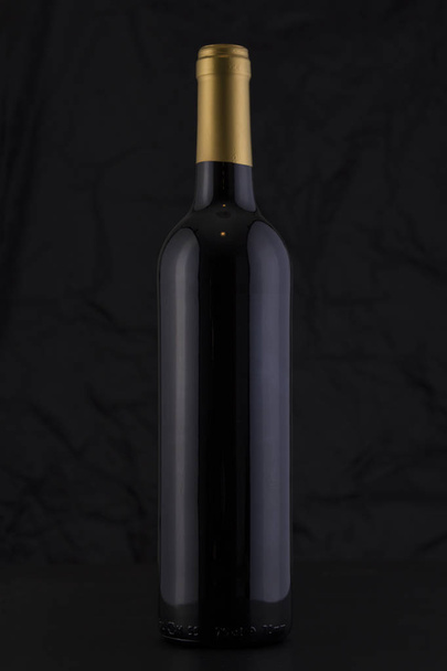 Isolated Red Wine Bottle in a Black Background - Photo, Image