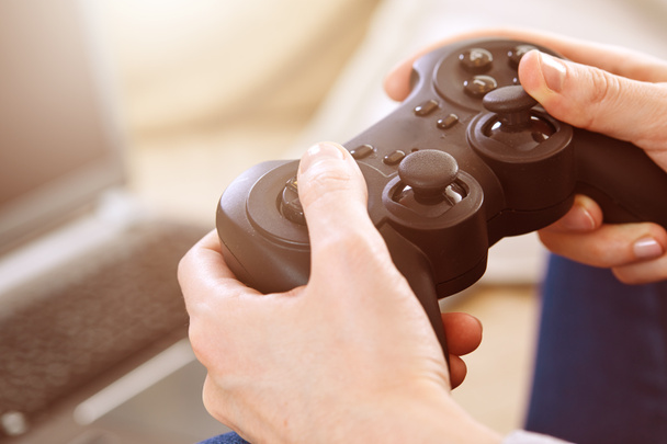 άνθρωπος που κρατά χειριστήρια joystick παίζοντας βιντεοπαιχνίδια στο σπίτι - Φωτογραφία, εικόνα