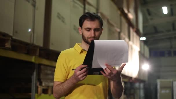 The warehouse worker makes an inventory of the goods. The male storekeeper recounts the goods in the warehouse and makes notes. Manager work in the warehouser - Footage, Video