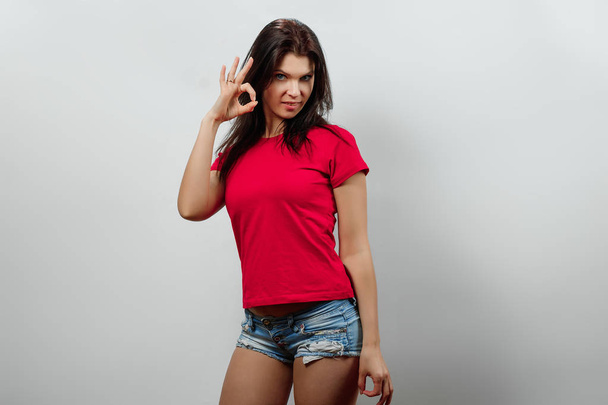 Young, beautiful girl showing hands gesture ok. Isolated on a light background. Different human emotions, feelings of facial expression, attitude, perception, body language, reaction. - Foto, Imagem