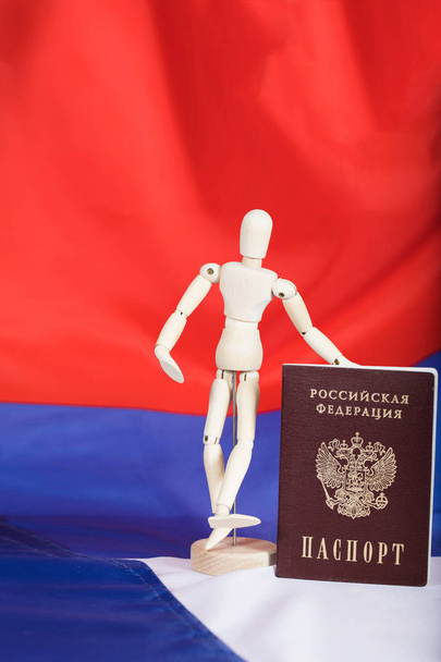 Passaggio russo e figurina manichino in legno sulla bandiera russa
.  - Foto, immagini