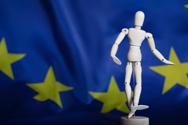 Wooden dummy figurine on European flag. - Photo, Image