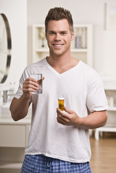 Homme attrayant avec de l'eau et des pilules
 - Photo, image