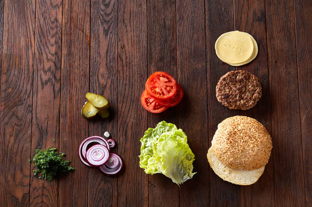 Tasty hamburger ingredients are laid out separately from above, beautifully harmoniously, close-up, top view - Foto, immagini