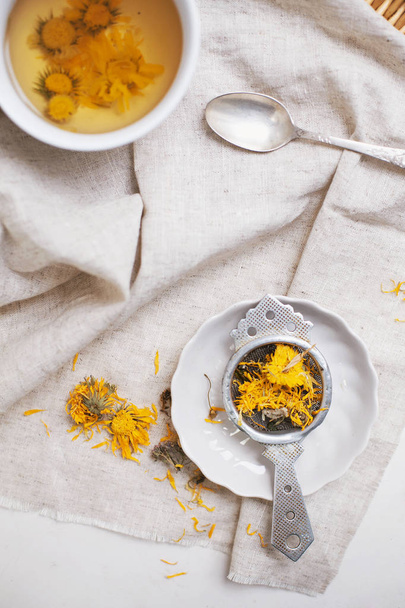 Herbal calendula tea in white cup and strainer - Photo, Image