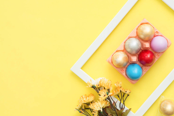 Lapos laikus felülnézet színes húsvéti tojást festett pasztell színek összetétele és a tavaszi virágok, pasztell színű háttérrel. Húsvéti nap háttér felső nézetben másol hely. - Fotó, kép
