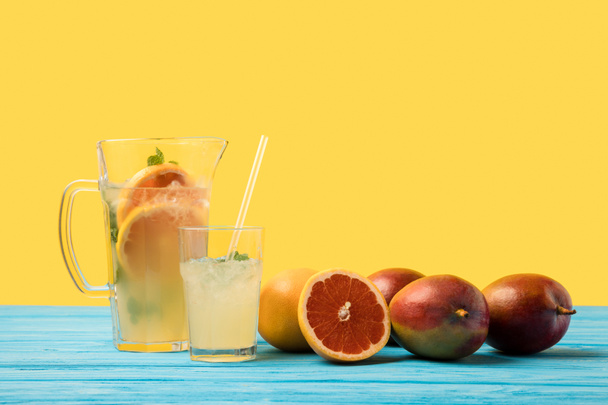 tuoreet kypsät trooppiset hedelmät ja kylmä kesä cocktail lasi ja kannu turkoosi puinen pöytälevy
  - Valokuva, kuva