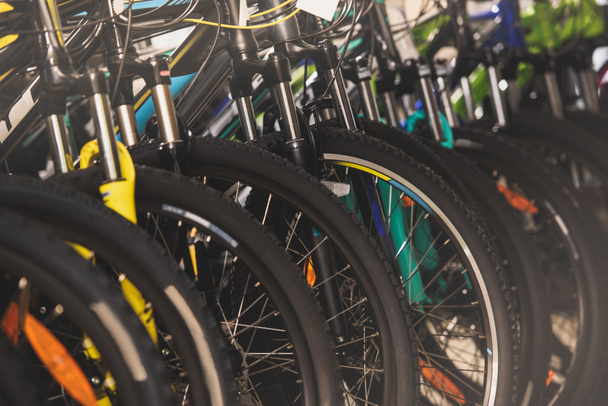 close-up view of wheels of bikes selling in bicycle shop - Foto, afbeelding