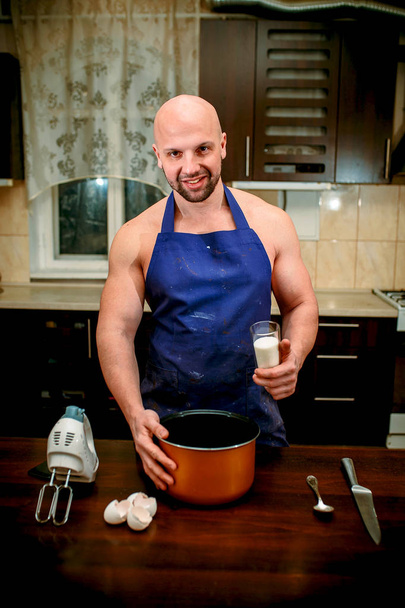 Ένας νεαρός άνδρας είναι το μαγείρεμα σε μια μεγάλη κουζίνα - Φωτογραφία, εικόνα