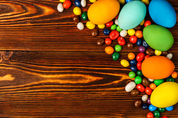Delicious easter eggs and sweets on a wooden background - Foto, Imagem