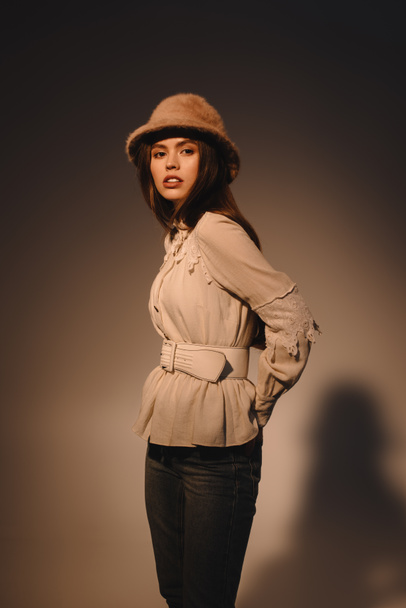 portrait of beautiful woman in fashionable clothing and hat posing on dark background - Foto, immagini