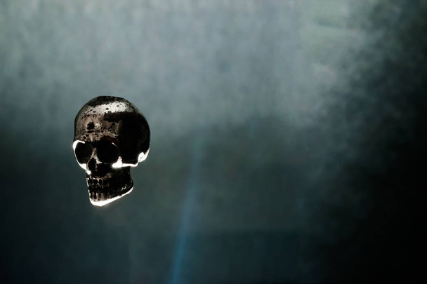Işıkla aydınlatılmış siyah arka plan üzerinde havada metal Skull Levitating - Fotoğraf, Görsel
