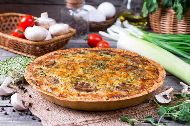 hausgemachte französische Quiche-Torte mit Pilzen und Käse vor rustikalem Holzhintergrund - Foto, Bild