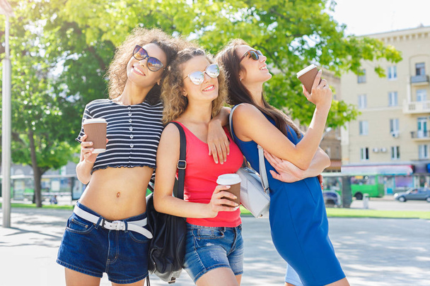 Meninas felizes com tirar café ao ar livre
 - Foto, Imagem