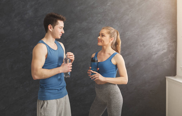 Fitness casal água potável no ginásio
 - Foto, Imagem