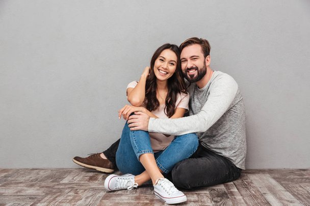 Cheerful handsome man with his wife sitting isolated - Foto, Bild