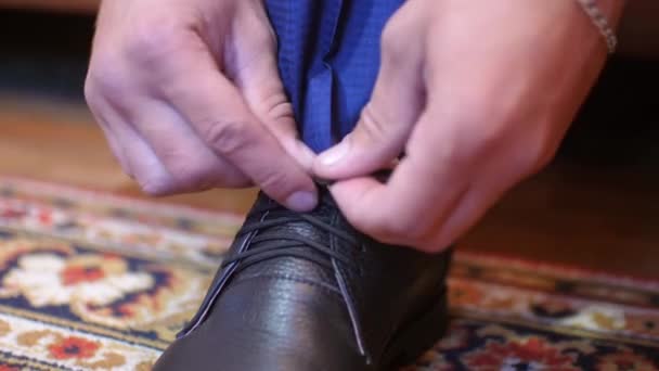 Mann schnürt Schnürsenkel an schwarzen Schuhen - Filmmaterial, Video