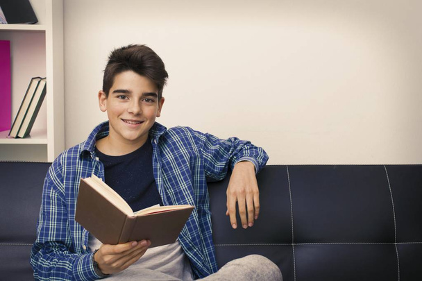 kind, tiener of preteen lezen of studeren thuis - Foto, afbeelding