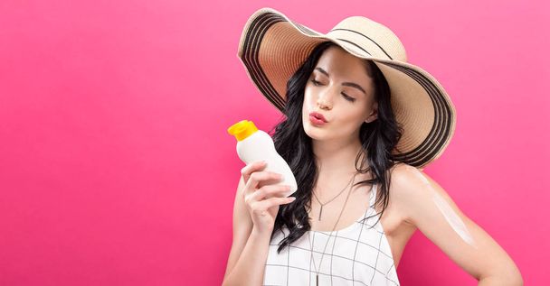 Young woman holding a bottle of sunblock - Фото, зображення