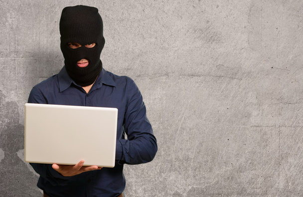 Fiatal férfi tolvaj gazdaság laptop - Fotó, kép