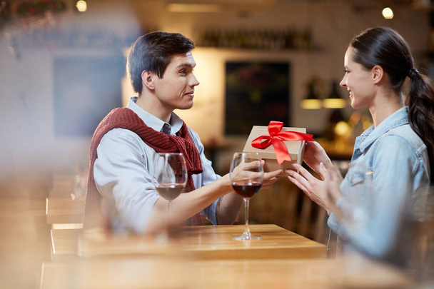 Amorous guy giving his girlfriend box with present for valentine day - Foto, Imagem