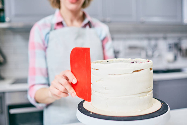 Professional foodstylist or confectioner putting marzipan glaze all over festive cake - Fotoğraf, Görsel