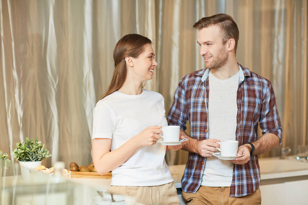 Nuori mies ja vaimo kahvilla keittiössä ja puhuu aamulla
 - Valokuva, kuva