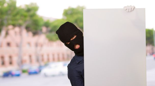 Homem assaltante segurando Placard em branco
 - Foto, Imagem