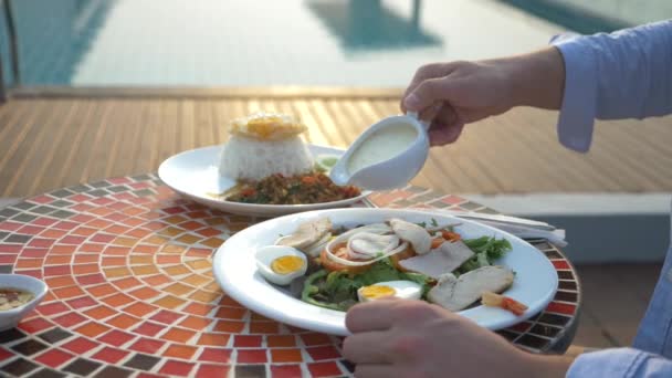 Креветочный суп - это тайское блюдо с кислым и острым вкусом. Человек ест Тома Яма за столом у бассейна. 4К, замедленная съемка, крупный план. Концепция туризма
 - Кадры, видео