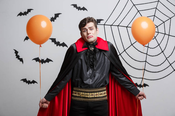 Portrait of handsome caucasian in Vampire halloween costume with colorful Balloon. - Photo, image