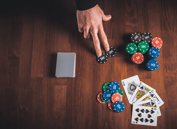 Persona mostrando su cubierta en el póquer juego
 - Foto, Imagen