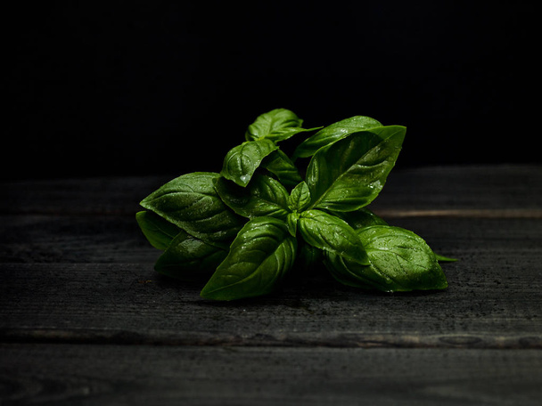 Basil on wooden table. Food ingredients still life - Photo, Image