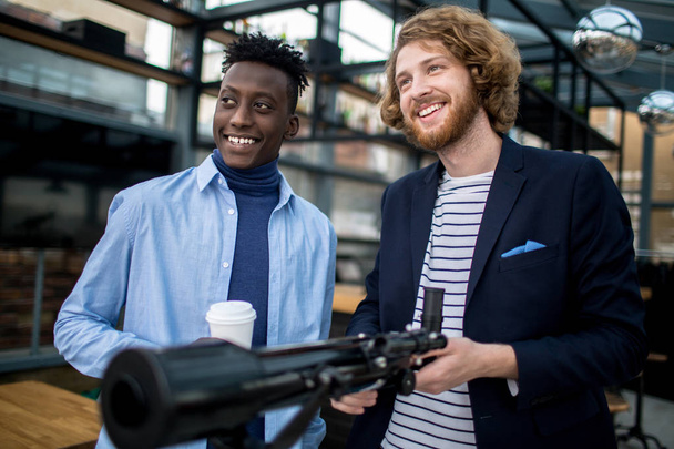 Two happy modern businessman with telescope looking straight and smiling - Photo, image