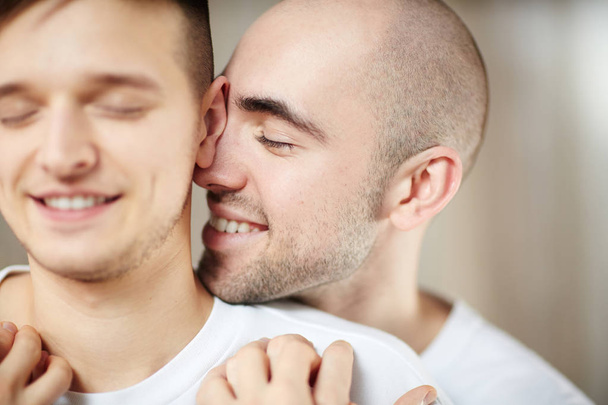 Young smiling man expressing love and tenderness to his partner - 写真・画像