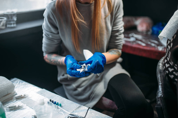 ženské tattooist v modrých sterilní rukavice Příprava tetování stroj, mistr v salonu - Fotografie, Obrázek