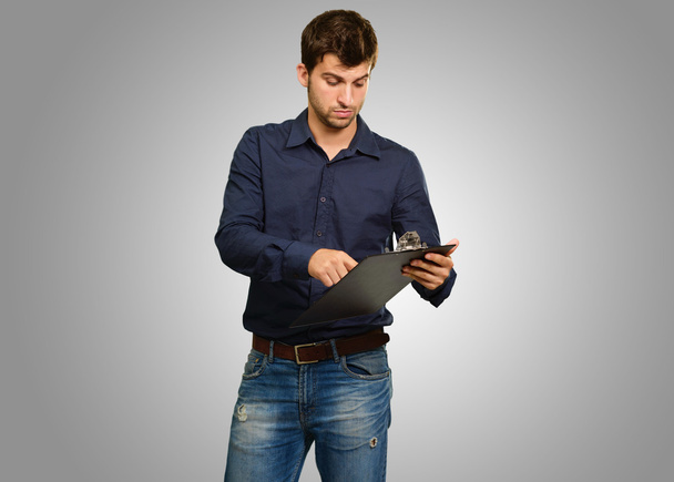 Young Man Holding Clipboard - Foto, imagen