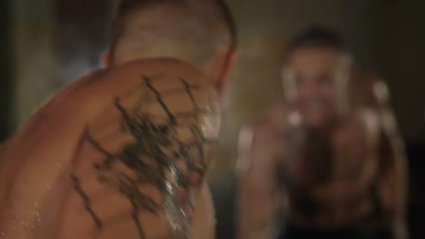 Bezvlasý s tetováním zdarma bojovník zdvihá činky před zrcadlem. 4k - Záběry, video