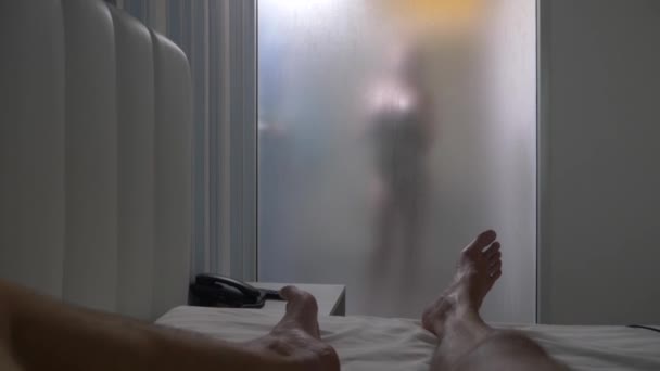 Woman behind blurry glass. Girl preparing take shower. Woman in bathroom. a man watches as a woman takes a shower through a glass wall in the shower. 4k - Záběry, video